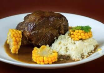 pike's peak roast with mash potato and corn on a white plate