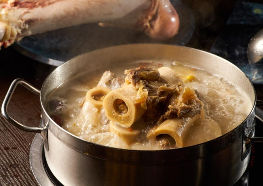 meaty beef bones in boiling pot making stew